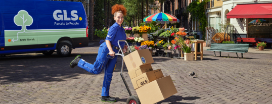 Frau mit Paketen auf Sackkarre