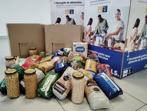 GLS food donation campaign with boxes and non-perishable products such as legumes, pasta, and canned goods, aimed at helping families in need.