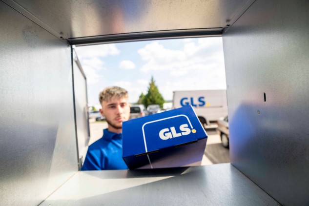 Entrega de paquete en locker desde el interior: repartidor de GLS depositando una caja azul en un locker en un entorno de última milla.
